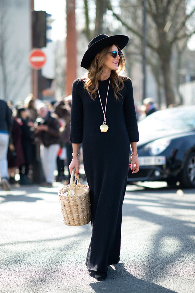 vestido longo preto com bolsa de palha e chapéu preto